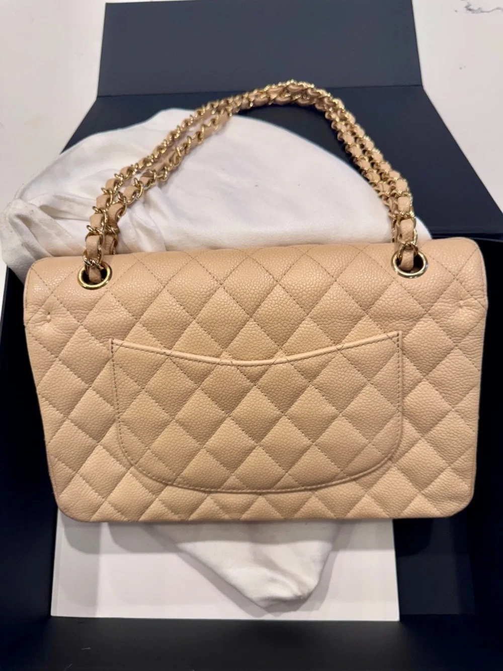 Chanel Classic Medium Double Flap in beige nude caviar with gold tone hardware.